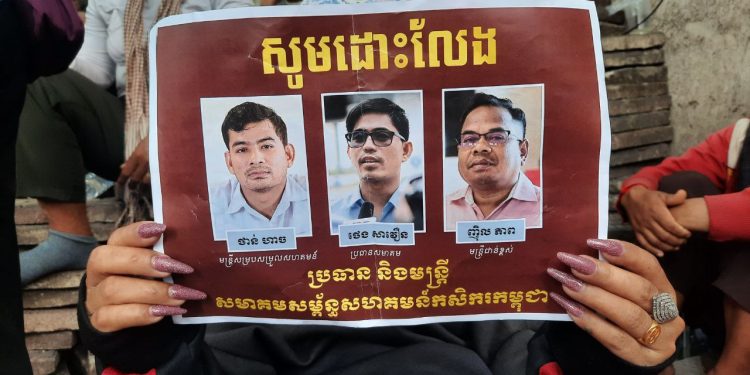 រូបថតប្រធានសមាគមសម្ព័ន្ធសហគមន៍កសិករកម្ពុជាលោក ថេង សាវឿន លោក ញ៉ិល ភាព ជាមន្ត្រីជាន់ខ្ពស់សមាគម និងលោក ថាន់ ហាច ជាមន្ត្រីសម្របសម្រួលសមាគម ដែលពលរដ្ឋប្រមាណ៣០០នាក់ នាំគ្នាលើកបង្ហាញដើម្បីតវ៉ានៅមុខក្រសួងមហាផ្ទៃ កាលថ្ងៃទី១៩ ខែឧសភា ឆ្នាំ២០២៣ ស្នើសុំទៅរដ្ឋមន្ត្រីក្រសួងមហាផ្ទៃលោក ស ខេង ជួយអន្តរាគមន៍ដោះលែងពួកគេឱ្យមានសេរីភាពវិញ។ (លោក អ៊ុក ដែន)